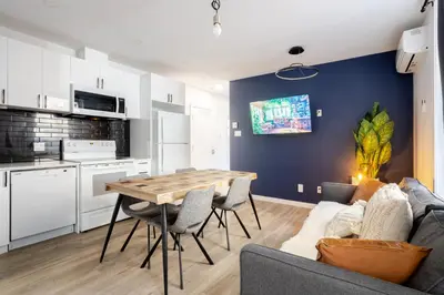 a kitchen and living room with a table and a couch at Warm 2BR in the Heart of Plateau MTL in Montréal
