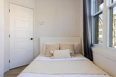 a bed in a room with a window at Warm 2BR in the Heart of Plateau MTL in Montréal