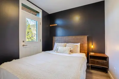 a bedroom with a white bed with a black wall at The Perfect Downtown Hideaway in Montréal