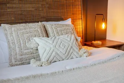 a bed with white pillows on it with a lamp at The Perfect Downtown Hideaway in Montréal
