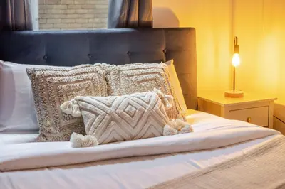 a bed with a blue headboard and pillows on it at The Perfect Downtown Hideaway in Montréal