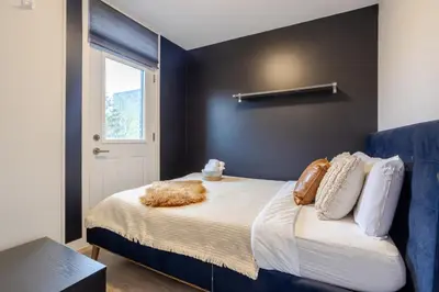 a bedroom with a bed with a black wall at Spacious 4BR 2BA in the Plateau Montreal in Montréal