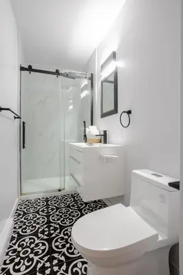 a white bathroom with a shower and a toilet at Spacious 4BR 2BA in the Plateau Montreal in Montréal