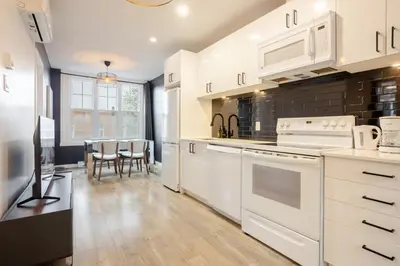 a kitchen with white appliances and a dining room at Spacious 4BR 2BA in the Plateau Montreal in Montréal