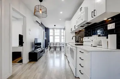 a kitchen with white cabinets and a dining room at Spacious 4BR 2BA in the Plateau Montreal in Montréal