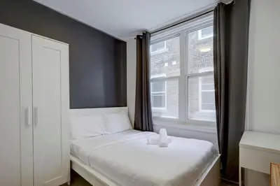 a small bedroom with a bed and a window at Vibrant 4BR 2BA Retreat in the Plateau in Montréal