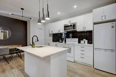 a kitchen with white cabinets and a white counter top at Vibrant 4BR 2BA Retreat in the Plateau in Montréal