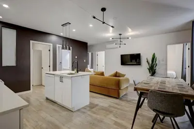 a kitchen and living room with a couch and a table at Vibrant 4BR 2BA Retreat in the Plateau in Montréal