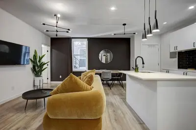 a kitchen and living room with a couch and a table at Vibrant 4BR 2BA Retreat in the Plateau in Montréal