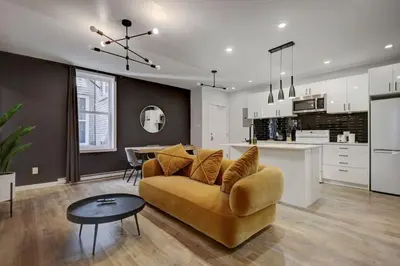 a living room and kitchen with a couch and a table at Vibrant 4BR 2BA Retreat in the Plateau in Montréal
