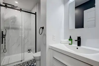 a white bathroom with a sink and a shower at Vibrant 4BR 2BA Retreat in the Plateau in Montréal