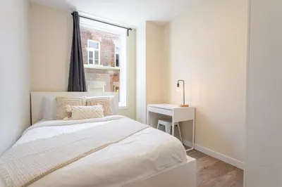 a white bedroom with a bed and a window at Stunning 3BR on in Plateau Mont-Royal in Montréal