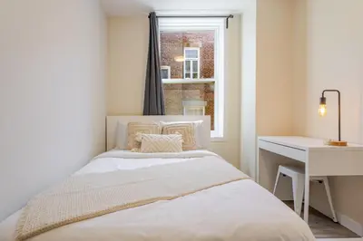 a bedroom with a bed and a desk and a window at Stunning 3BR on in Plateau Mont-Royal in Montréal