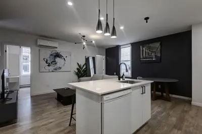 a kitchen with a sink and a living room at Elegant 4BR on in the Plateau MTL in Montréal