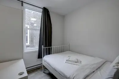 a small bedroom with a bed and a window at Elegant 4BR on in the Plateau MTL in Montréal