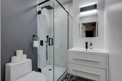 a bathroom with a shower and a toilet and a sink at Elegant 4BR on in the Plateau MTL in Montréal