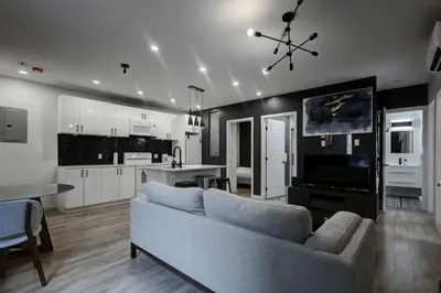 a living room with a couch and a kitchen at Elegant 4BR on in the Plateau MTL in Montréal