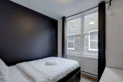 a small bedroom with a bed and a window at Elegant 4BR on in the Plateau MTL in Montréal
