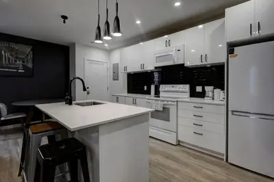 a kitchen with white cabinets and white appliances at Elegant 4BR on in the Plateau MTL in Montréal