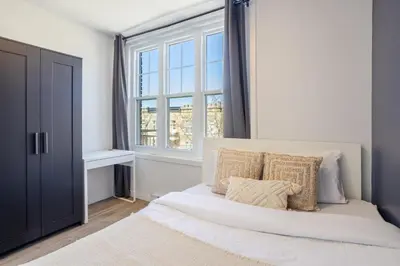 a bedroom with a white bed with a window at Amazing 3-Bedroom on Saint-Urbain in Montréal