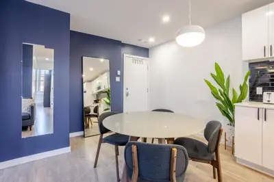 a dining room with a white table and chairs at Amazing 3-Bedroom on Saint-Urbain in Montréal