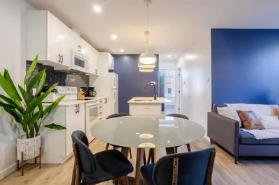 a kitchen and living room with a table and chairs at Amazing 3-Bedroom on Saint-Urbain in Montréal