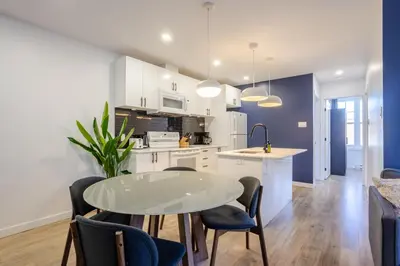 a kitchen and dining room with a table and chairs at Amazing 3-Bedroom on Saint-Urbain in Montréal
