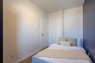 a small bedroom with a bed and a door at Amazing 3-Bedroom on Saint-Urbain in Montréal