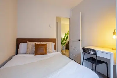 a bedroom with a bed and a desk and a chair at Beautiful 3BR in MTL Mont-Royal in Montréal