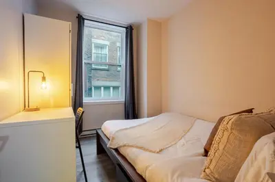 a small bedroom with a bed and a window at Beautiful 3BR in MTL Mont-Royal in Montréal