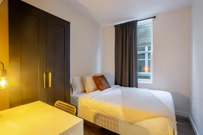 a bedroom with a bed and a table and a window at Beautiful 3BR in MTL Mont-Royal in Montréal