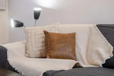 a blanket sitting on top of a couch with pillows at Beautiful 3BR in MTL Mont-Royal in Montréal