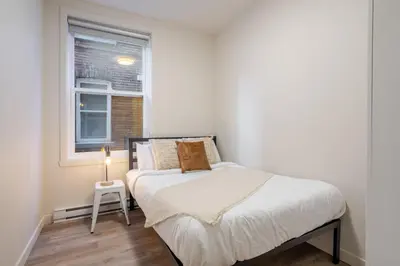 a small bedroom with a bed and a window at Bright 3BR 2BA in the Plateau in Montréal