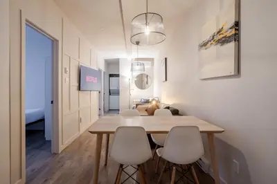 a dining room with a table and white chairs at Bright 3BR 2BA in the Plateau in Montréal