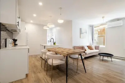 a kitchen and living room with a table and chairs at Charming 3BR in the Plateau MTL in Montréal