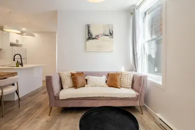 a living room with a couch and a kitchen at Charming 3BR in the Plateau MTL in Montréal