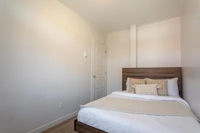 a bedroom with a large bed with white walls at Charming 3BR in the Plateau MTL in Montréal