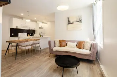 a living room and kitchen with a couch and a table at Charming 3BR in the Plateau MTL in Montréal