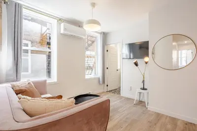 a living room with a couch and a mirror at Charming 3BR in the Plateau MTL in Montréal