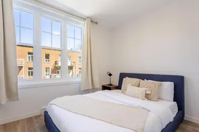 a bedroom with a bed and a large window at Charming 3BR in the Plateau MTL in Montréal