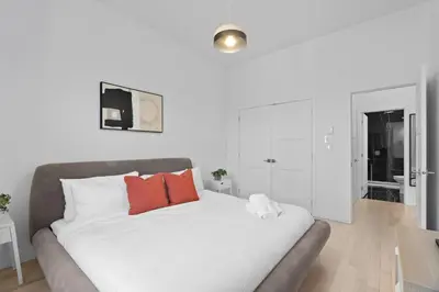 a white bed with red pillows in a room at New Modern 2bdr Apartment in Little Italy Unit 202 in Montréal