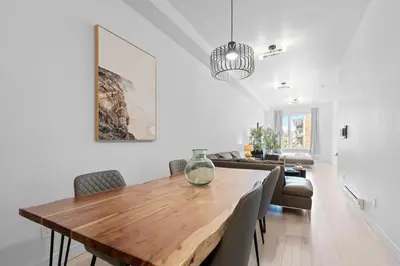 a dining room with a wooden table and chairs at New Modern 2bdr Apartment in Little Italy Unit 202 in Montréal
