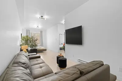 a living room with a couch and a flat screen tv at New Modern 2bdr Apartment in Little Italy Unit 202 in Montréal