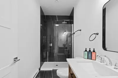 a bathroom with a shower and a sink and a toilet at New Modern 2bdr Apartment in Little Italy Unit 202 in Montréal