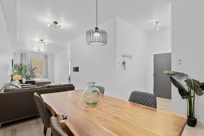 a dining room with a table and a couch at New Modern 2bdr Apartment in Little Italy Unit 202 in Montréal