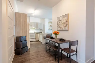 a kitchen with a table with a vase of flowers on it at Large Suite in Downtown Montreal in Montréal