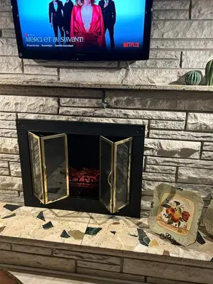 a fireplace with a tv on a brick wall at Logement 1 pièce Cozy - Parfait pour Courts Séjours in Montréal