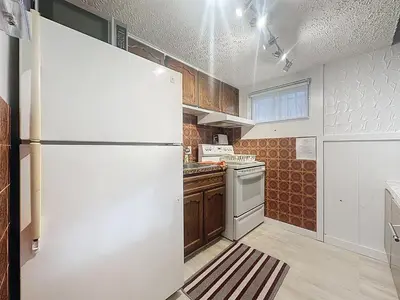 a kitchen with a white refrigerator and a stove at Logement 1 pièce Cozy - Parfait pour Courts Séjours in Montréal
