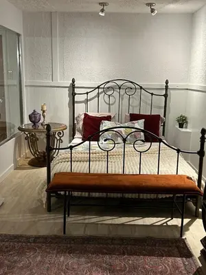 a bedroom with a metal bed with red pillows at Logement 1 pièce Cozy - Parfait pour Courts Séjours in Montréal