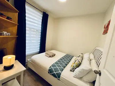 a small bedroom with a bed and a window at Heart of the City Stay in Montréal